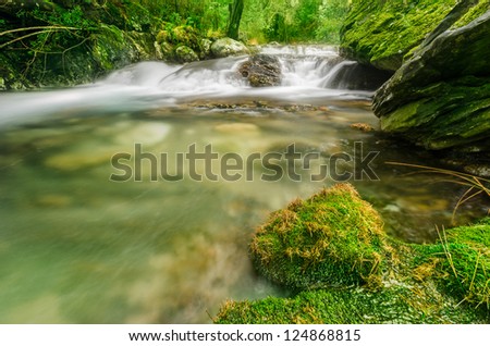 Mountain waterfall, stream of water in forest and mountain terrain.