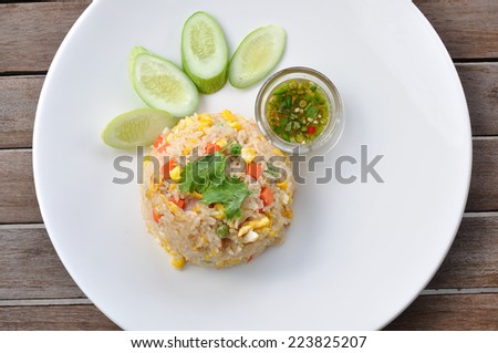 Pork fired rice in white plate on wooden table, TOP VIEW.