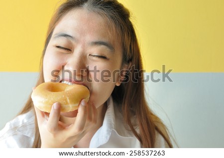 Asian business woman 28 years old in uniform eating plain donut. junk food.