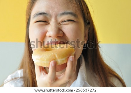 Asian business woman 28 years old in uniform eating plain donut. junk food.