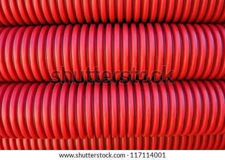 Abstract background of rolled red plastic electrical conduit for use in underground cable installation