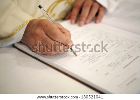 Priest signing the marriage register