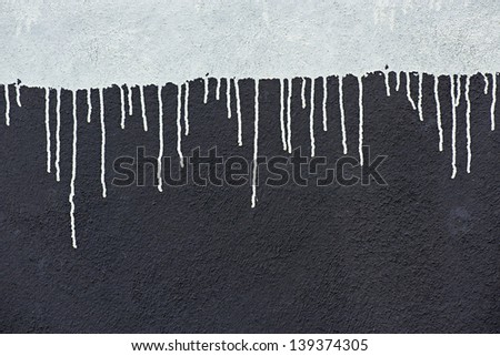 Gray paint drops on a dark gray wall