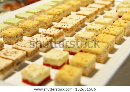 Small individual gourmet savory appetizers lined up on a buffet table at a catered function or event