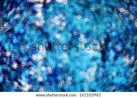 Abstract blue background with a random blurred pattern of splashes of color in turquoise, blue and white