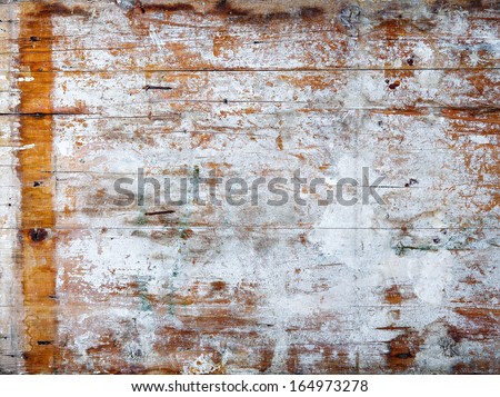 Grunge wood background texture with weathered white paint and cracks on a wooden panel