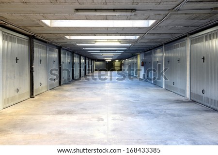 Two rows of metal garage doors on either side of a covered internal drive through