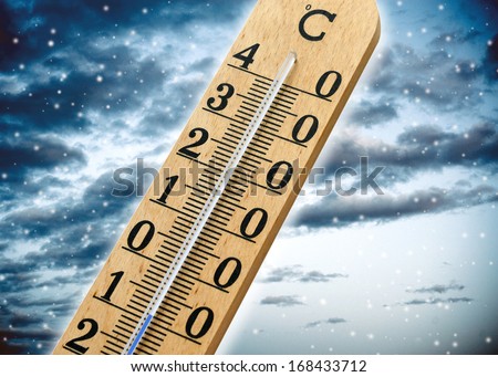 Thermometer showing cold weather and a sub zero temperature over a blue snowy winter background