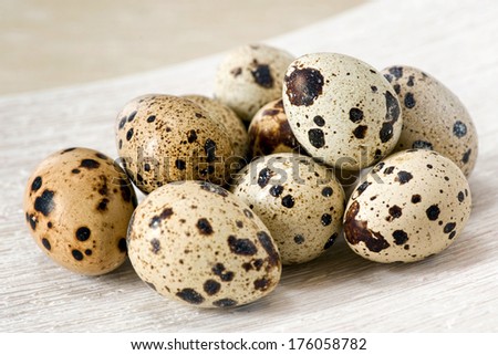 Closeup of spotted nutritious quail eggs, natural source of vitamins and minerals, on a rustic wooden surface