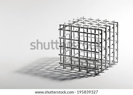 Open empty cube frame with a square lattice and equilateral sides on a white background with a shadow and copy space