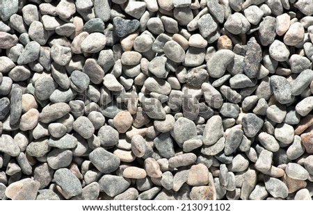 Background texture of smooth water worn stones, gravel or pebbles used in landscaping a garden, building construction or found in a riverbed