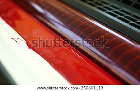 Close up Pure Red Ink on the Edge of Printing Machine.