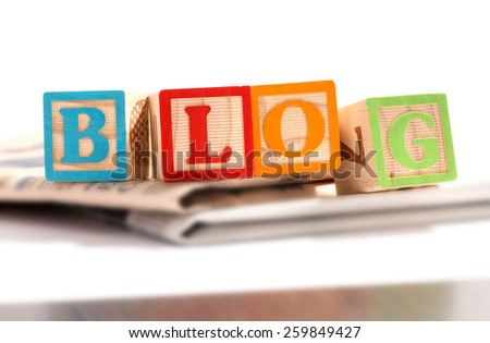 Close up Colored Letter Blocks on Top of Newspapers for a Blog Concept. Isolated on White Background.