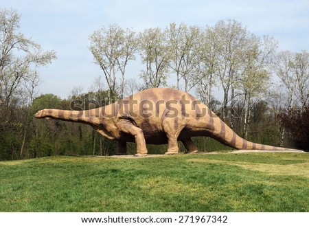 April 10, 2015 Prehistoric Park, Rivolta D\' adda, Lombardy, Italy : Brontosaurus Dinosaur, Animal During the Late Jurassic Period, Standing at the Park with Green Grasses and Tall Trees.