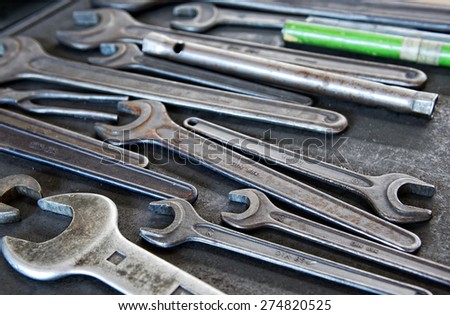 Still Life Close Up of Collection of Well-Used Metal Wrenches in Variety of Sizes on Work Tray