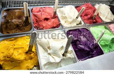 Colorful display of an assortment of freshly made different fruity flavored Italian ice cream in the window of an ice cream parlour or shop for sale as takeaway desserts
