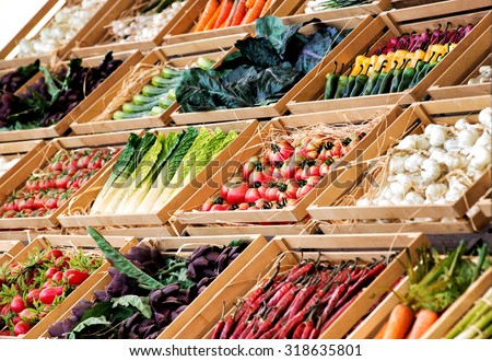 Display of assorted farm fresh vegetables on a market stall or in a store neatly arranged in rows in wooden boxes