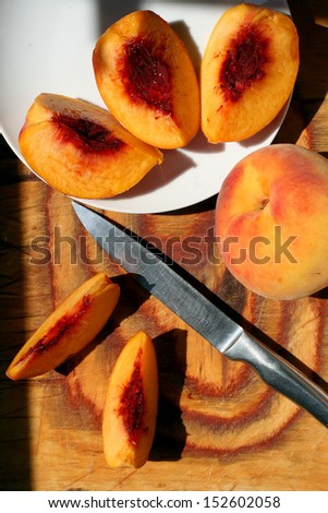 Sliced fresh peaches on wood board