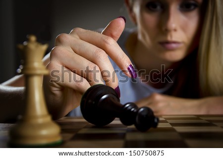woman surrendering her king after loosing a game of chess