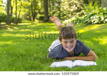 Boy reading a book in the park