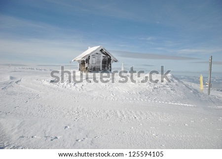 Winter mountain landscape with small shelter house and snowy pillars