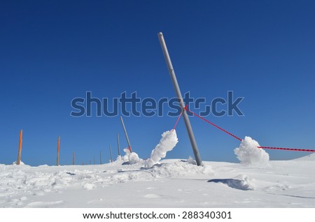 Iron and wooden pillars, red rope, lot of snow and clear sky, mountain ski resort  Kopaonik, Serbia