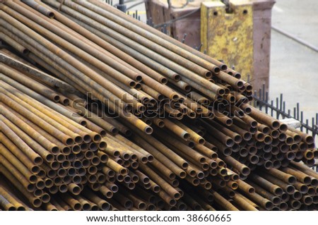 Warehouse of metal pipes. Rusty pipes lay on the earth.