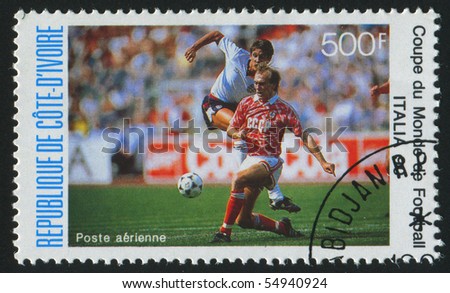IVORY COAST - CIRCA 1990: stamp printed by Ivory Coast, shows Soccer players and ball, circa 1990.
