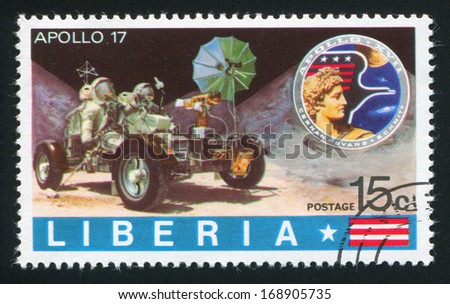 LIBERIA - CIRCA 1973: stamp printed by Liberia, shows Apollo badge and astronauts in lunar rover exploring moon crater, circa 1973
