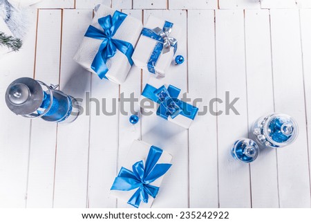 white Christmas gifts with blue ribbon on white wooden floor