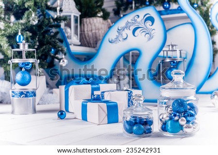 white Christmas gifts with blue ribbon on white wooden floor, Christmas balls in glass transparent bank