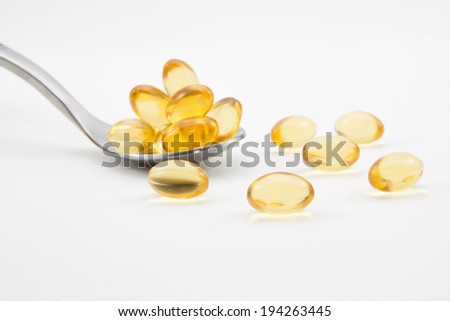 Omega-3 pills on spoon.