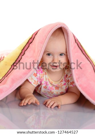 baby girl is hiding under the blanket over white background