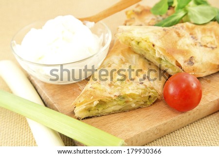 Leek pie slices with the cream and fresh vegetables