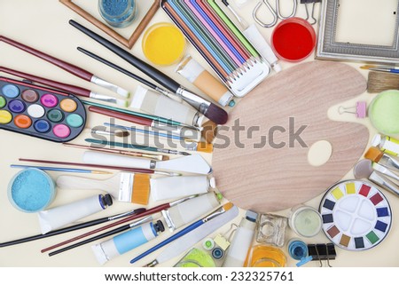 Painting equipments on a beige cardboard background