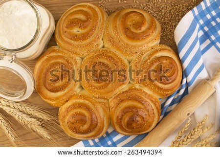 Flower shaped bread with wheat, jar of flour and the wheat ears