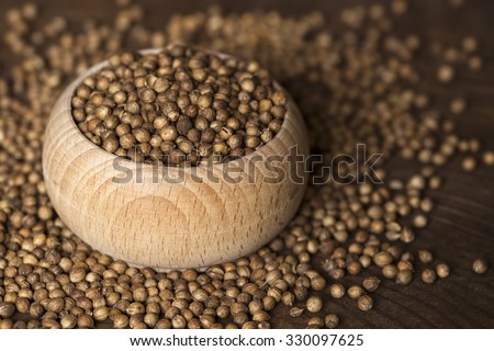 Coriander seeds in a small wooden bowl