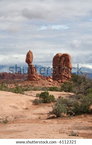 View of Balanced Rock with La Sal Mountain Range in the distance from Arches National Park in Utah.
