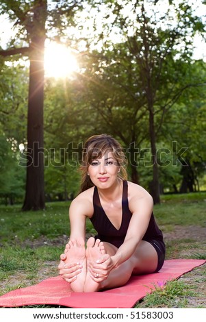 Seated forward fold yoga pose at sunset in the park