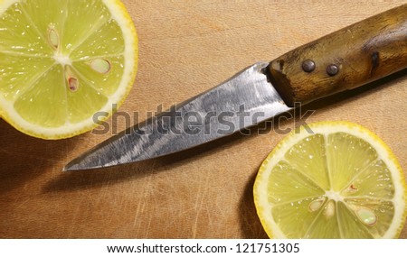 old knife and lemon on cutting board