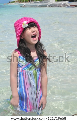 a beautiful Chinese girl laughing in the sea of  the Bohol Island of  Philippines