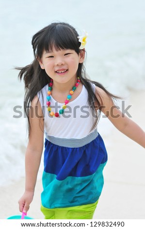 a lovely Chinese girl running happily on the beach of Philippines
