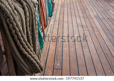 Rope control the sails, tied to a wooden beam, on sailboat