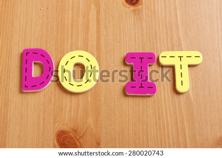 DO IT, spell by woody puzzle letters with woody background