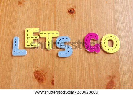 LETS GO, spell by woody puzzle letters with woody background