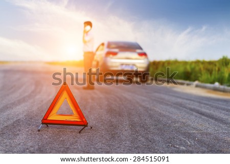 Car with problems and a red triangle to warn other road users