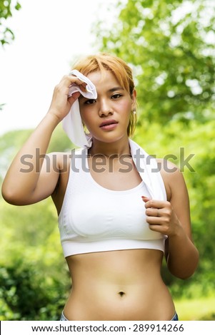 Athlete woman wiping sweat from her forehead with a towel after