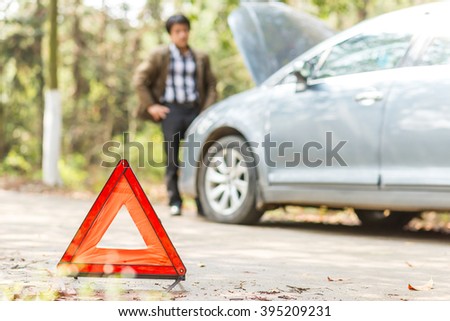 Car with problems and a red triangle to warn other road users