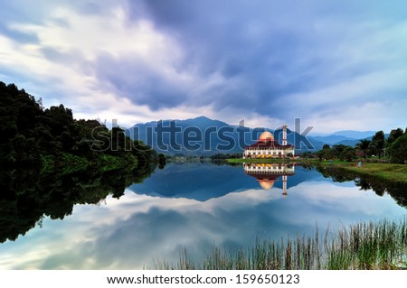 Beautiful mosque with mirror like reflection in the morning with dramatic cloud
