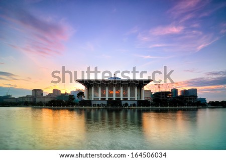 Beautiful mosque with reflection in Putrajaya, Malaysia by the lakeside during sunrise
